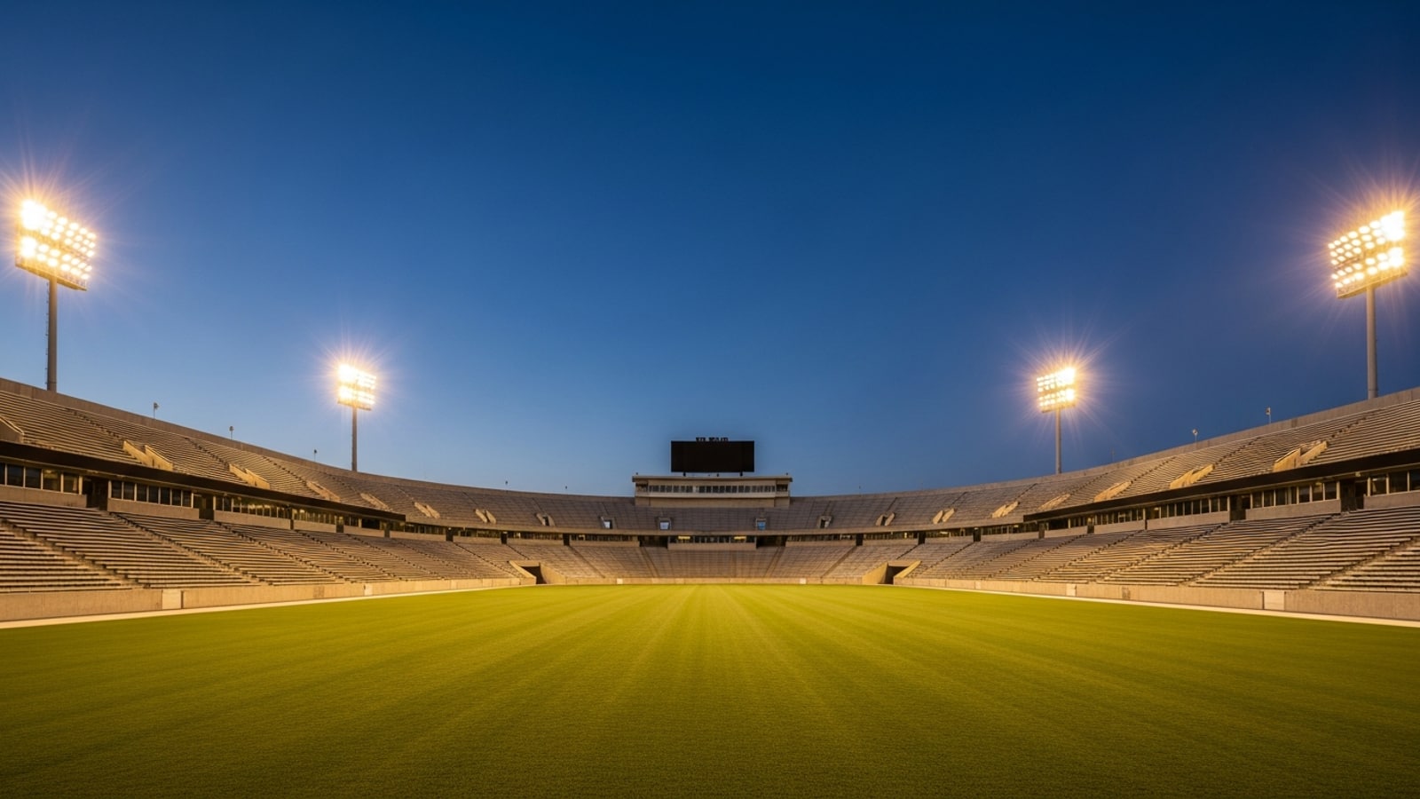 Empty collegiate stadium bleachers at dusk conveying the scale of the recruiting journey