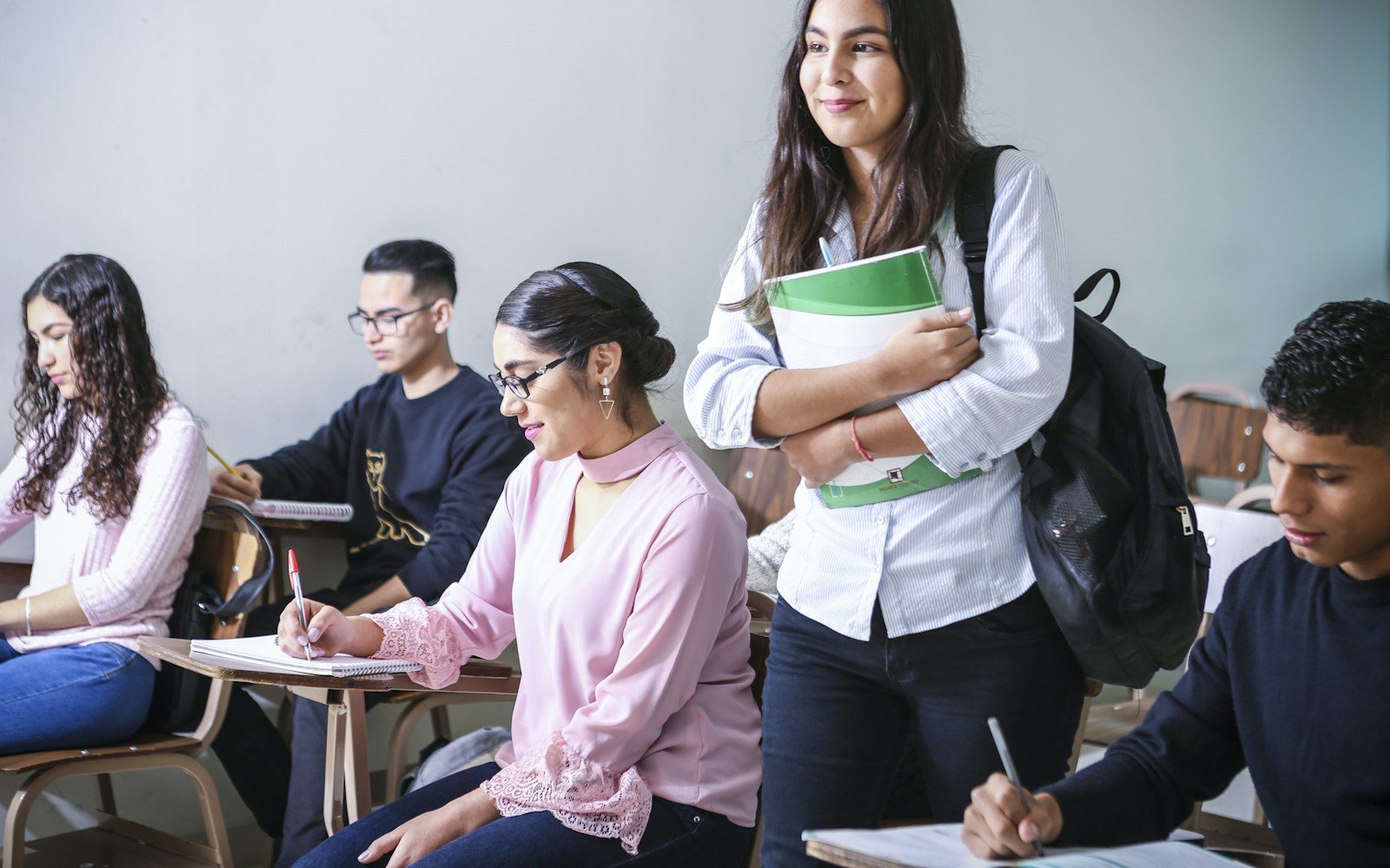 Students taking notes in a classroom during a lesson