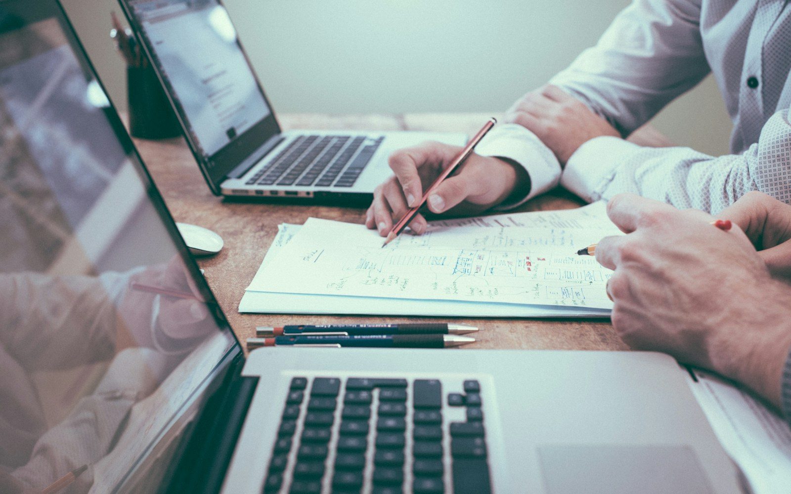 People planning together with notes and laptops on a desk